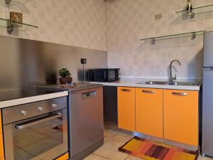 a kitchen with orange cabinets and a sink at casa Veronica in Pieve Di Ledro