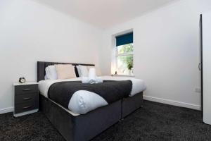 a bedroom with a large bed and a window at Contractor Stay - 4 Beds Games Room Secure Parking in Bishop Auckland