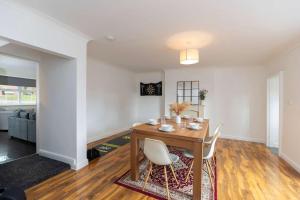 a living room with a wooden table and chairs at Contractor Stay - 4 Beds Games Room Secure Parking in Bishop Auckland