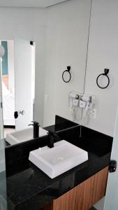 a bathroom with a white sink and a mirror at Style and lightness 300m from the beach in Salvador +101 photos