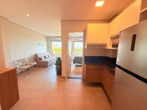 a kitchen and a living room with a couch at Style and lightness 300m from the beach in Salvador