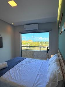 a bedroom with a bed and a large window at Style and lightness 300m from the beach in Salvador