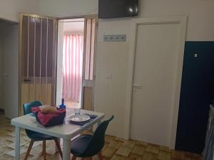 a room with a table and chairs and a door at Mare Sole Vento 38 Punta Prosciutto in Torre Colimena