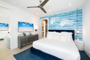 ein Schlafzimmer mit einem großen weißen Bett und einer blauen Wand in der Unterkunft Rum Point Resort 307 in Driftwood Village