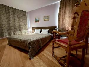 プレヴェンにあるFamily Art Hotel Galleryの部屋にベッドと椅子がある寝室