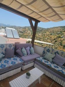 ein Balkon mit Couch und Tisch und Aussicht in der Unterkunft Casa mi sùeño azul in Torrox