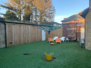 a garden with a yellow bucket on the grass at Spacious Holiday let midway between Edinburgh and Glasgow with three shower rooms in Kirk of Shotts