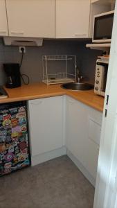 a kitchen with white cabinets and a sink and a refrigerator at Studio 4pers vue piste in Le Corbier