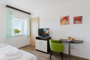 a room with a bed and a table and a television at Langs Wirtshaus in Sankt Ulrich im Mühlkreis