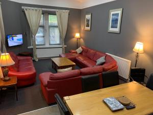 a living room with a couch and a table at Spacious Holiday let midway between Edinburgh and Glasgow with three shower rooms in Kirk of Shotts
