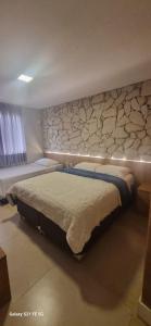 ベレンにあるHotel Amazônico - Beira Rioのベッドと石の壁のある寝室