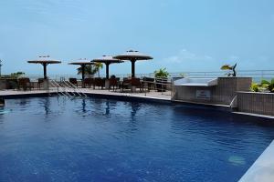 a swimming pool with tables and umbrellas on a building at Pipa's bay - Praia do Amor in Pipa