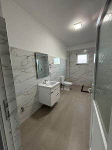 a bathroom with a sink and a toilet at Bujtina e Kadrise in Kukës +10 photos
