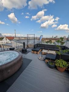 a rooftop deck with a hot tub and furniture on a building at Best Penthouse in Vienna, 7min to 1st district in Vienna