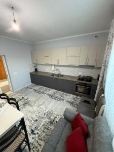 a living room with a couch and a kitchen at Bujtina e Kadrise in Kukës