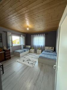 a bedroom with two beds and a wooden ceiling at Bujtina e Kadrise in Kukës