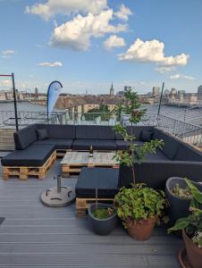a patio with a couch and a table on a roof at Best Penthouse in Vienna, 7min to 1st district in Vienna
