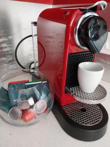 una cafetera roja sentada en un mostrador con una taza en Villa Manuia, à Punaauia, en Punaauia
