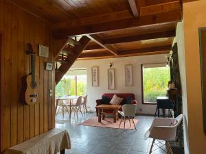 a living room with a couch and a table with a guitar at Hostel Raíz in Pucón