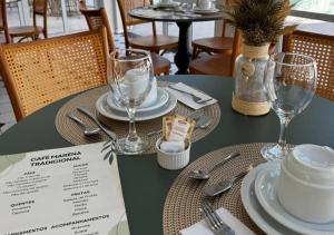 a green table with plates and glasses on it at Santé Vivre L'Experience by Livá OFICIAL in Búzios