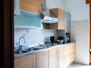 a kitchen with wooden cabinets and a sink at Civico 5 in Piacenza +4 photos