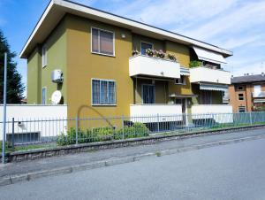 a yellow house with a white fence in front of it at Civico 5 in Piacenza