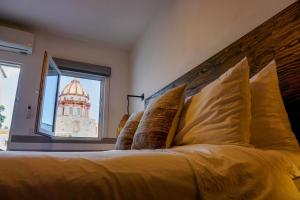 a bedroom with a large bed with a large window at Casa Yuca Hotel in San Miguel de Allende