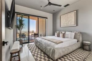 a bedroom with a large bed and a balcony at Sunstill by Fieldtrip Modern w Custom Pool Spa Views in Joshua Tree +42 photos