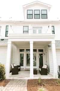 a white house with two chairs on a patio at 527 The Cape Henry House in Virginia Beach +75 photos