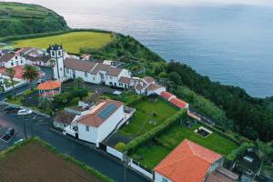 an aerial view of a house on a hill next to the water at Casa da Vigia, Seaview House - sleeps 8 people in Feteira Grande
