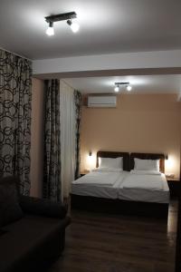 1 dormitorio con cama y sofá en Center Guest House en Sapareva Banya
