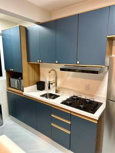 パリョサにあるApartamento NOVO e moderno em palhoçaの青いキャビネットとシンクのあるキッチン