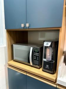 パリョサにあるApartamento NOVO e moderno em palhoçaの電子レンジ、トースターオーブン(棚に座る) +20枚の写真