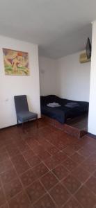 a room with two beds and a chair and a tile floor at БіднийЗаяць in Lebedevka