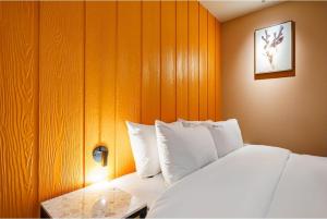 a bedroom with a bed with white pillows at 12번길stay  +17 photos