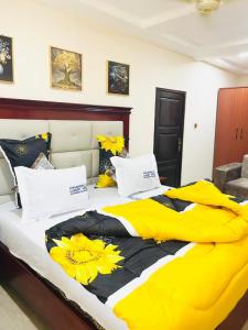 にあるPharrell Luxury Hotelの黄色と黒のベッド、黄色のシーツと枕