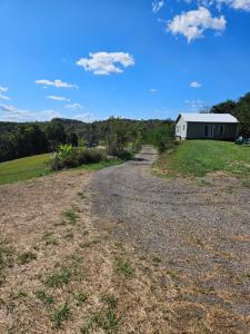 ローガンにあるThe Hocking Hills Store Campsite #1の白い建物へ続く未舗装道路