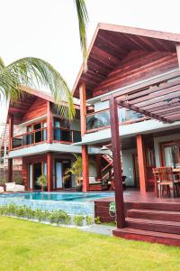 a house with a swimming pool in front of it at Hura Vilas in Itarema +4 photos
