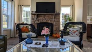 a living room with a fireplace with two chairs and a table at Spacious Entire home close to HoliMont and Village in Ellicottville +21 photos