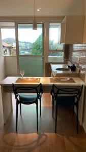 una cocina con 2 sillas y una mesa con gafas. en Flat no Centro de Campo Grande, en Campo Grande 2 fotos más