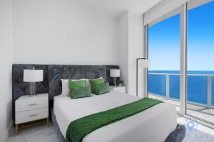 a bedroom with a large bed and a large window at Oceanfront Penthouse -3BR + Pool + Beach access in Hollywood Beach