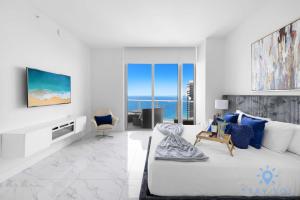 a white bedroom with a large bed and a view of the ocean at Oceanfront Penthouse -3BR + Pool + Beach access in Hollywood Beach