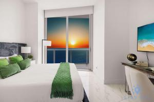 a bedroom with a large bed and a large window at Oceanfront Penthouse -3BR + Pool + Beach access in Hollywood Beach