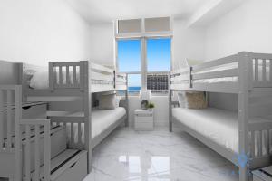 a white room with bunk beds and a window at Oceanfront Penthouse -3BR + Pool + Beach access in Hollywood Beach