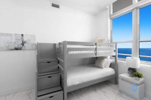 a bedroom with a bunk bed with a window at Oceanfront Penthouse -3BR + Pool + Beach access in Hollywood Beach +53 photos