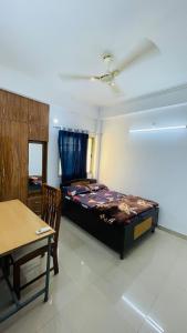 Un dormitorio con una cama y una mesa dentro. en Leafora A Class Apart from the Usual Stay, en Lucknow