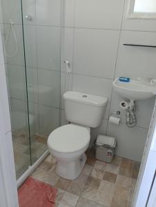 a bathroom with a toilet and a sink and a shower at Casa aconchegante na praia in Cabo Frio +10 photos