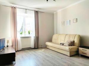 Una sala de estar con un sofá y una ventana. en relax apartament, en Skarzysko-Kamienna