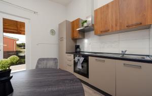 una cucina con armadi bianchi, tavolo e lavandino di One-Bedroom Apartment In Podgradina a Islam Grčki