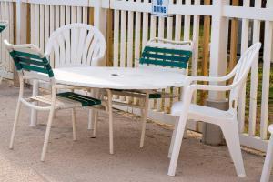 three chairs and a white table and chairs at Island Inn By OYO Galveston Beach, TX in Galveston